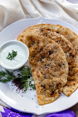 Geleneksel Azeri mutfağı. Qutabs gözleme beyaz seramik plaka üzerinde. Dikey kompozisyon.