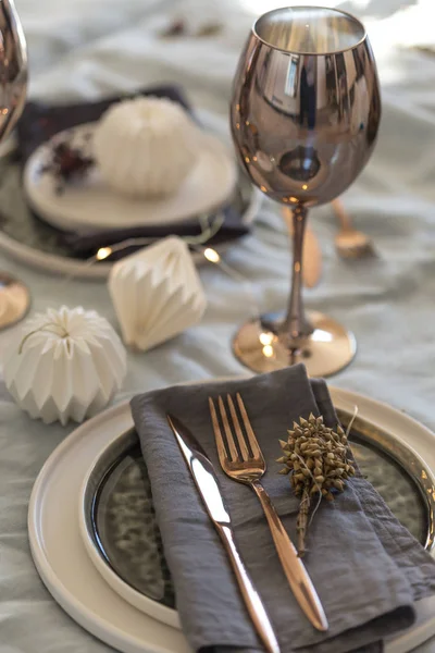 Christmas table setting with stoneware ceramic plates and origami decorations