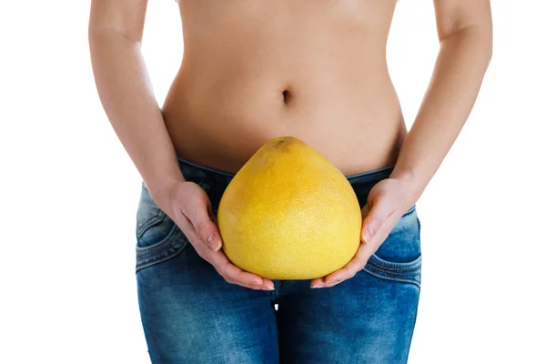 Kadın göbeği. Pomelo holding kadın eller. Tüp Bebek, gebelik, diyet kavramı.