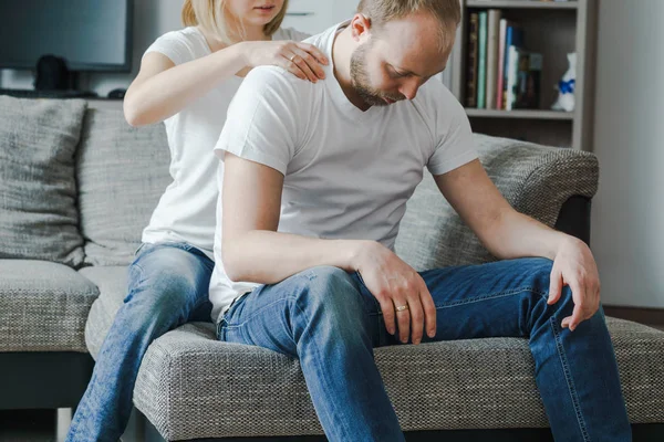 Hombre sentado mientras está siendo masajeado por una mujer en la habitación en casa . — Foto de Stock