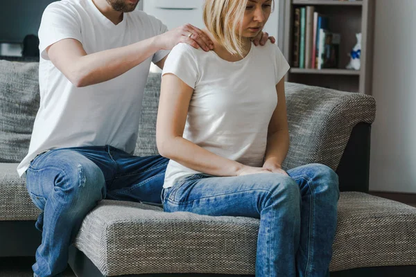 Imagen natural del estilo de vida de una joven sentada mientras es masajeada por un hombre en la habitación de su casa . — Foto de Stock