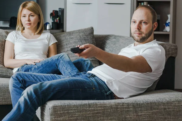 Natural, imagen de estilo de vida de pareja atractiva sentada en el sofá y preparándose para ver una película . — Foto de Stock