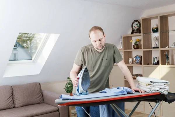 Hombre guapo planchando camisa en casa — Foto de Stock