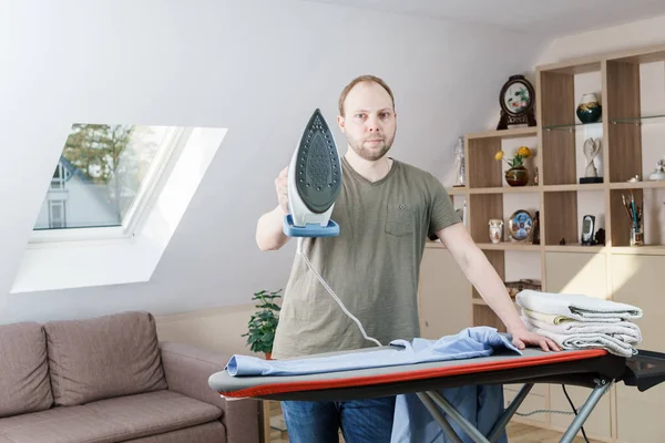 Hombre guapo planchando camisa en casa — Foto de Stock
