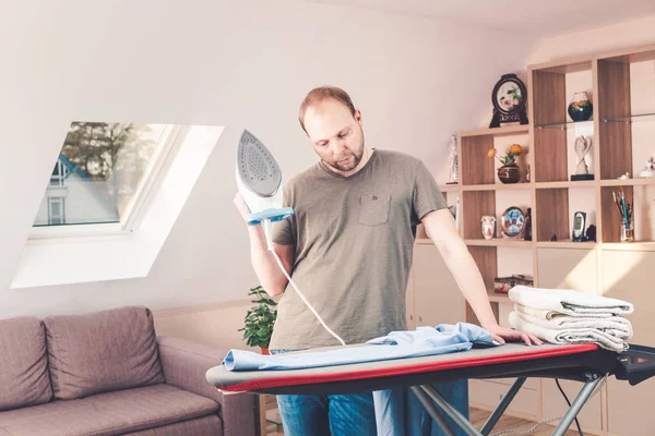 Hombre guapo planchando camisa en casa — Foto de Stock