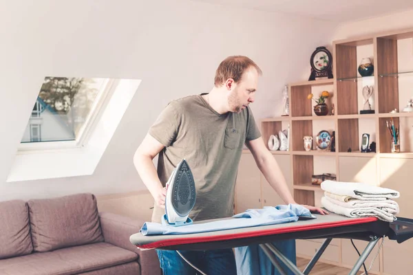 Hombre guapo planchando camisa en casa — Foto de Stock