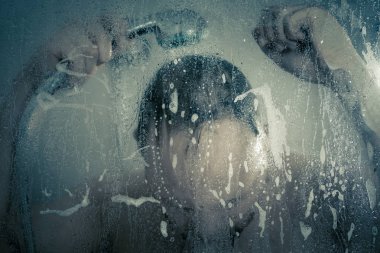 su akan ve duşakabin banyo şeffaf buğulu cam kapının arkasında kafasını tutarak altında ayakta duş alırken adam vurguladı