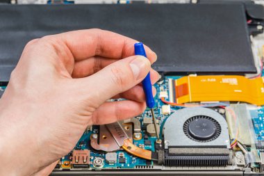 kişi eller bir tornavida ile laptop anakart tamiri