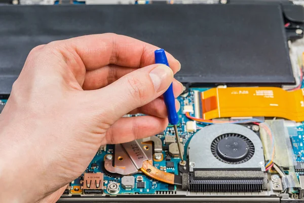 Mãos pessoa reparar placa-mãe laptop com uma chave de fenda — Fotografia de Stock