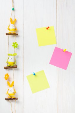 Yumurta dekorasyon mutlu Paskalya tavşanı Beyaz ahşap arka planda sarı ve pembe sticker notları ile.