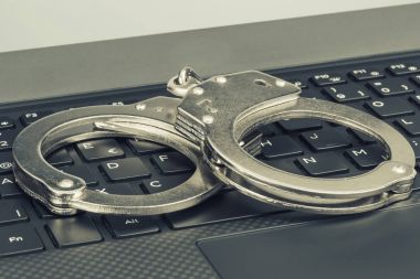 Kelepçe yeşil tonlama ile laptop. Hacker siber suç kavramı.
