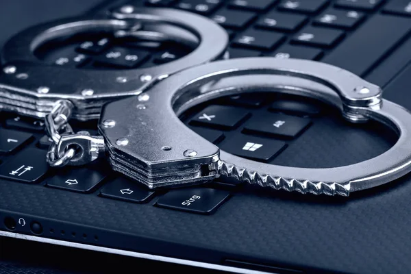 Kelepçe mavi tonlama ile laptop. Cyber hacker suç kavramı.