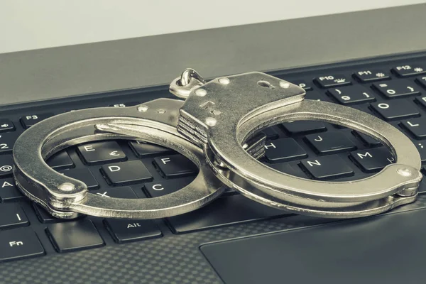 Kelepçe yeşil tonlama ile laptop. Hacker siber suç kavramı.
