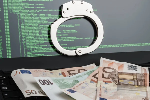 Kelepçe dizüstü ve para üstünde belgili tanımlık klavye. Cyber hacker suç kavramı.