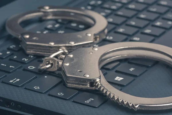 Handschellen auf dem Laptop in Großaufnahme. Konzept zur Cyberhacker-Kriminalität. — Stockfoto