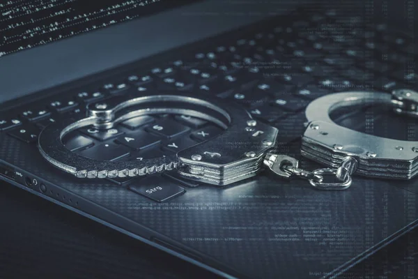 Kelepçe mavi dijital kod ile laptop. Cyber hacker suç kavramı.