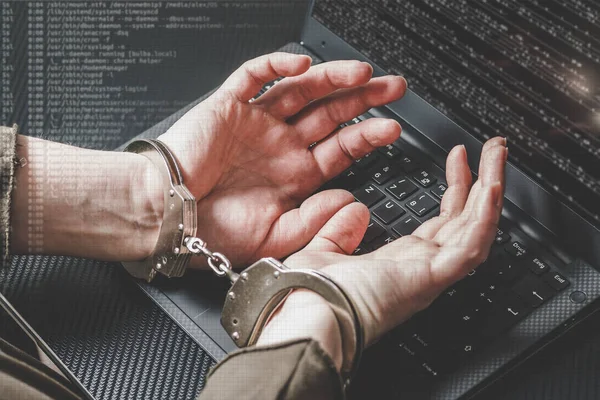 Hacker ellerinde kelepçe laptop klavye ve çevresinde dijital kod ile tutuklandı. Siber suç kavramı. Matt tonlama.