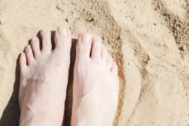 Kadın ve erkek ayakları üstünde kum plaj rahatlatıcı.