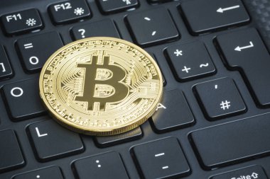 Laptop klavye üzerinde altın bitcoin. Kripto para kavramı.