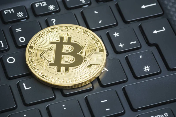 Laptop klavye üzerinde altın bitcoin. Kripto para kavramı.