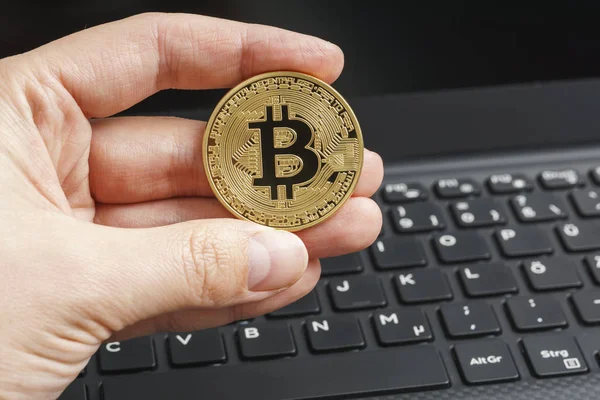 Altın bitcoin içinde parmak notebook klavye arka plan ile. Cryptocurrency kavramı.