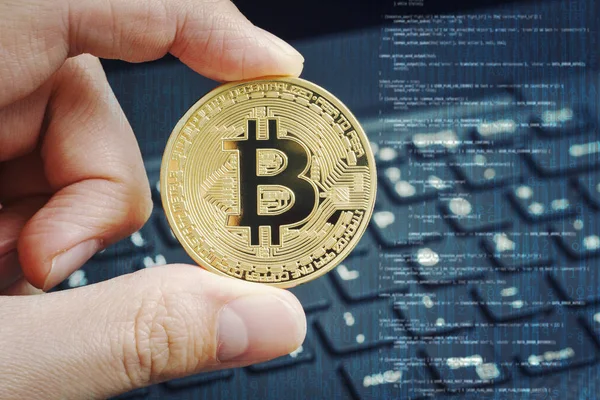 Parmak çevresinde dizüstü klavye arka plan ve programcı kodu tonlama mavi altın bitcoin. Kripto para kavramı.