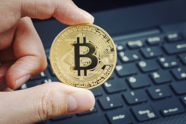 Altın bitcoin içinde parmak dizüstü klavye arka plan ile. Kripto para kavramı.