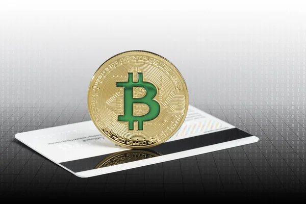 Criptomoeda física moeda verde bitcoin sobre o cartão de crédito . Fotografias De Stock Royalty-Free