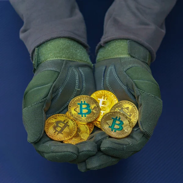 cryptocurrency yeşil bitcoin ile holding eller altın sikke üzerinde oturum.