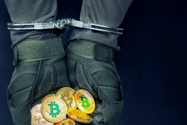 Puños arrestados esposas manos sostienen bitcoins de oro . Imagen de archivo