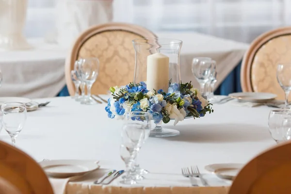 Vitt bord blå blommor ljus dekoration — Stockfoto