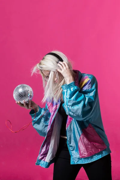 Mujer joven posando con una bola disco — Foto de Stock