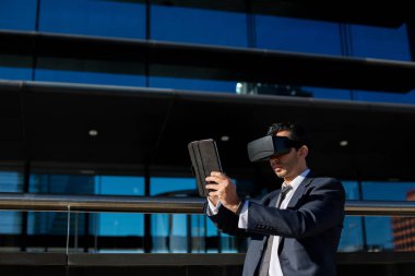 Tablet bilgisayar ve sanal gerçeklik gözlük kullanarak iş adamı