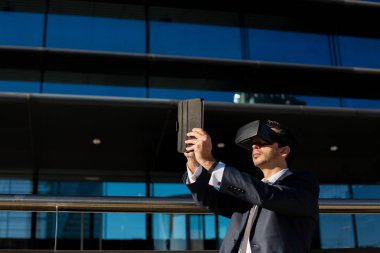 Tablet bilgisayar ve sanal gerçeklik gözlük kullanarak iş adamı