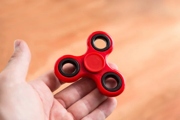 Homem segurando um fidget spinner — Fotografia de Stock