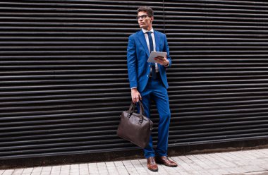 bir tablet bilgisayar kullanarak çekici iş adamı