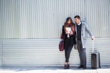 Birkaç turist sokakta tablet bilgisayar kullanarak