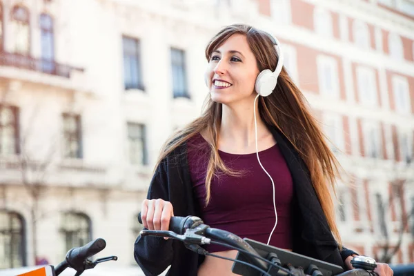 young woman listening to music in the street