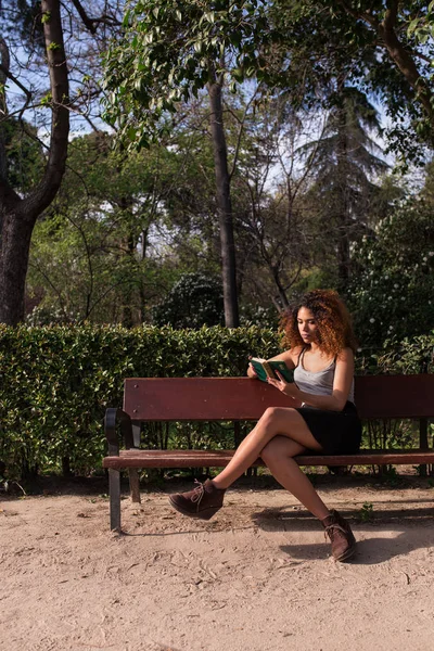 ผู้หญิงแอฟโรอ่านหนังสือบนเก้าอี้ — ภาพถ่ายสต็อก