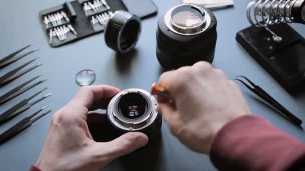 Hands with screwdriver repair photo camera lens — Stock Video