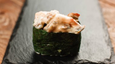 Bir suşi rulo siyah arduvaz makro vuruşta hizmet
