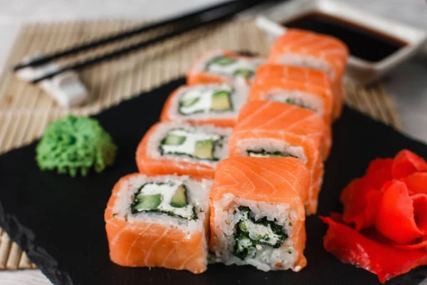Sushi fresco filadelfia appetitoso su ardesia nera — Foto Stock