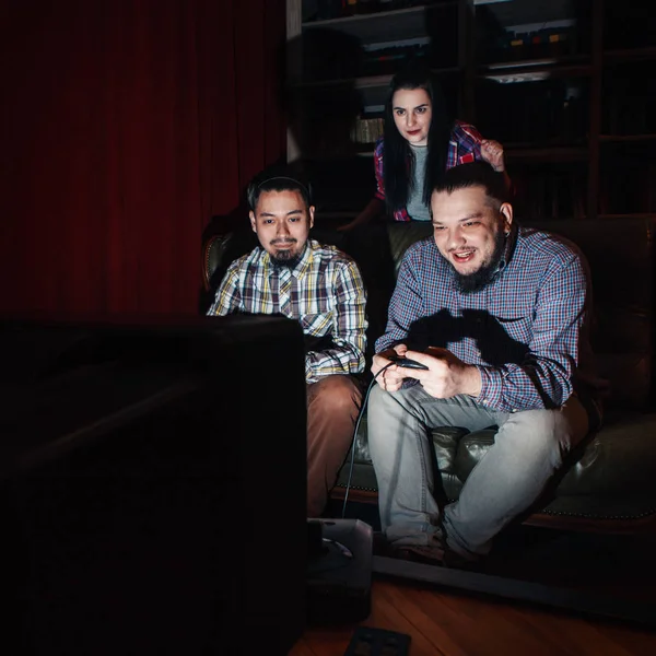 Two young guy play video game on couch, girl watch — Stock Photo, Image