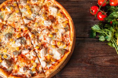 Tavuk ve Mısır pizza tahta masaya servis