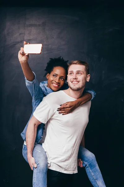 Homem dá piggyback passeio para mulher, casal selfie — Fotografia de Stock