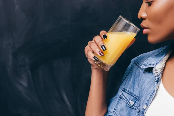 Primer plano de mujer negra con vaso de jugo de naranja — Foto de Stock