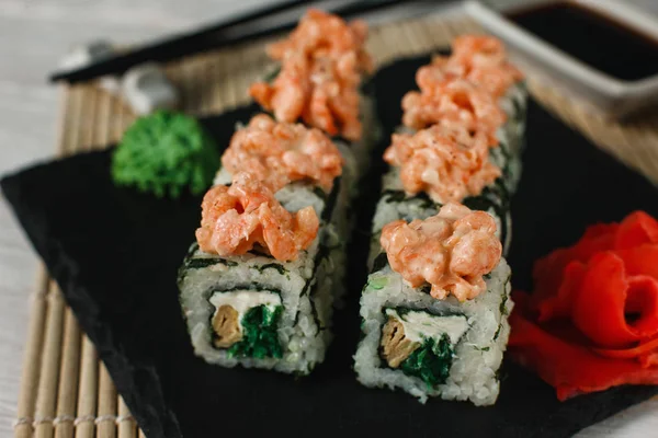 Japanese sushi, food art. Uramaki on black slate.