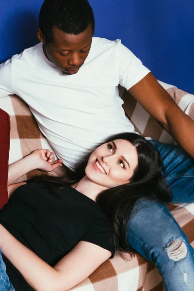 Weiße Frau und schwarzer Mann, Paar ruhen sich auf Couch aus — Stockfoto