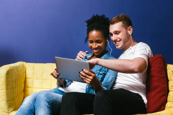 Sonriente pareja ver fotos en la tableta, sentarse en casa — Foto de Stock