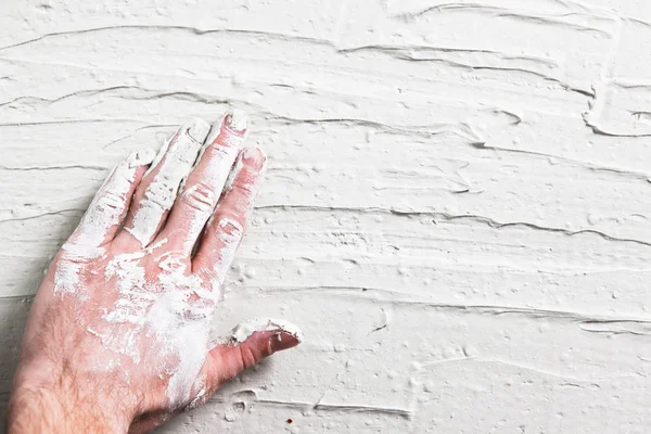 Repair background. Plaster wall with worker hand.
